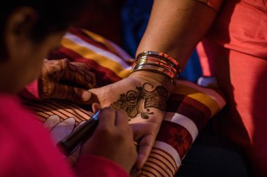 Kadın geleneksel dövme yapıyor.