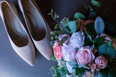 Güzel bir buket gül ve masa üzerinde ayakkabılar.