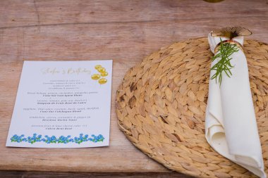 Ahşap bir masanın üzerinde bir buketle düğün dekoru.