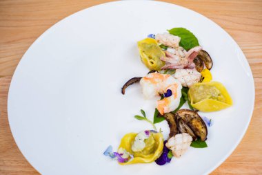 Beyaz tabakta midye, kalamar, mürekkep balığı ve ahtapot salatası..