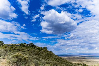 Bulutları ve mavi gökyüzü olan güzel bir manzara.