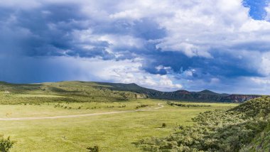 Arka planda gökkuşağı olan güzel bir manzaranın dikey çekimi.