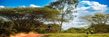 Bisikletçi yolda motosiklet sürüyor.