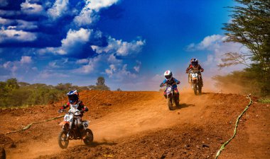 Bir grup genç motokros sürücüsü toprak yolda ilerliyorlar..