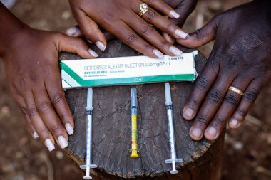 İğneyle şırınga tutan Afrikalı kadın.