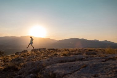 silhouette of a running man against the background of the sky and sunset in the mountains, sports and recreation.sport and health.