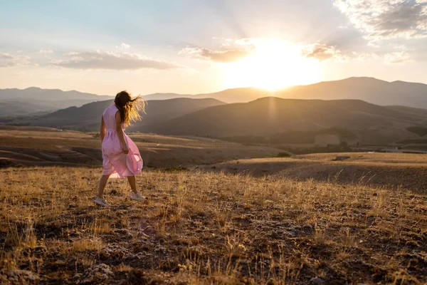 Girl Pink Dress Walks Field Backdrop Mountains Concept Freedom Joy — Stockfoto