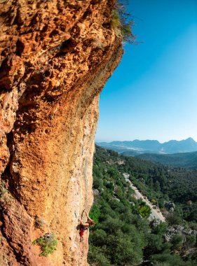Girl climbs on the rock, rock climbing in Turkey, the sports girl is engaged in rock climbing. extreme sport