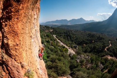 Girl climbs on the rock, rock climbing in Turkey, the sports girl is engaged in rock climbing. extreme sport