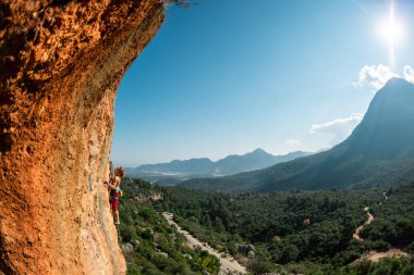 The girl climbs the rock. Climber trains on natural terrain. Extreme sport. Lessons on the street. A woman overcomes a difficult climbing route in Turkey. sports and adventure.