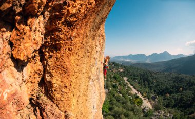 Girl climbs on the rock, rock climbing in Turkey, the sports girl is engaged in rock climbing. extreme sport
