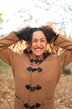 Güzel kız yürürken kırışıyor ve gülümsüyor. Samimi neşe ve eğlence duyguları.