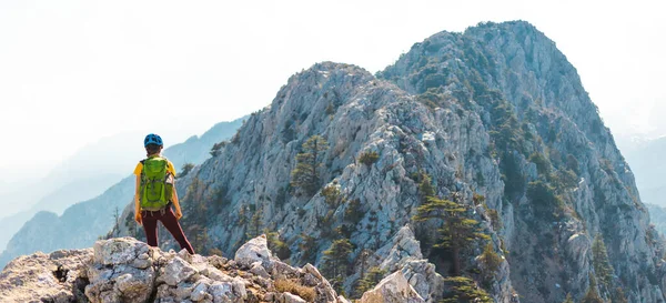 헬멧을 착용하고 등산하는 여자는 여름철에 등산을 경관을 즐긴다 — 스톡 사진