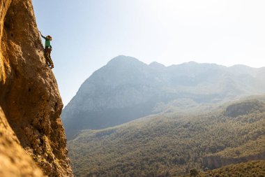 Girl climbs on the rock, rock climbing in Turkey, the sports girl is engaged in rock climbing. extreme sport