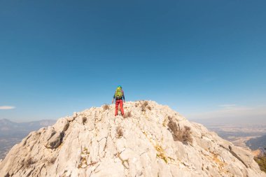Dağlarda yürüyüş. Sırt çantalı bir kız dağ sıralarında yürüyor. Tırmanış ve dağlarda yürüyüş..