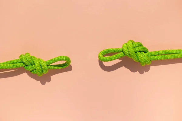 climbing rope with a knot lies on a colored background.  the concept of reliability and safety.