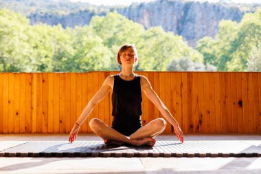 Genç atletik kadın antrenör yoga eğitmeni bireysel antrenman yapıyor. Denge pozisyonu, modern spor salonu, sağlıklı yaşam tarzı konsepti. Doğada spor.