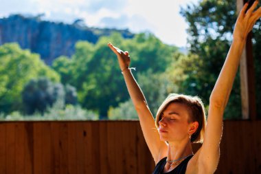 Kız yoga yapıyor. Genç atletik kadın antrenör yoga eğitmeni bireysel antrenman yapıyor. Denge pozisyonu, modern spor salonu, sağlıklı yaşam tarzı konsepti. Doğada spor