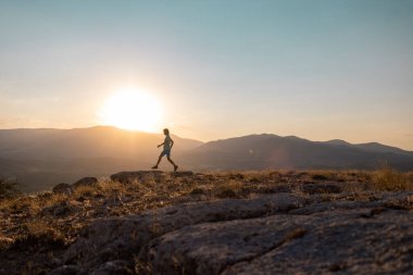silhouette of a running man against the background of the sky and sunset in the mountains, sports and recreation.sport and health.