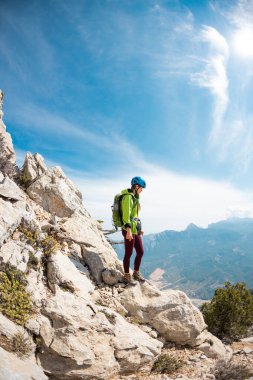 Dağcı dağın tepesinde duruyor. Kasklı ve sırt çantası dağlı bir kız. Macera konsepti ve dağlarda yürüyüş. Türkiye.