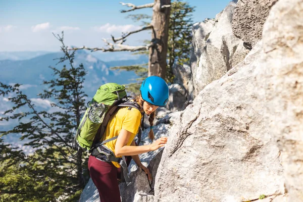 少女は岩に登っている 女性のバックパックと山の中でヘルメットを登る 冒険と登山の概念 山の中のリュックを持ってハイキングをしています トルコの山 — ストック写真