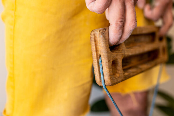 сильная мужская рука скалолаза держит доску для тренировки силы пальцев. скалолазание дома. Рука скалолаза крупным планом. сила и выносливость. Доска и дельтаплан