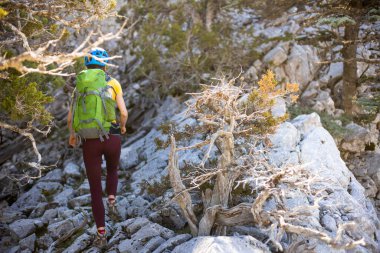 Dağcı kayalık tepe boyunca gider. Dağlara tırmanan bir kız. Macera konsepti ve dağlarda yürüyüş. Türkiye.