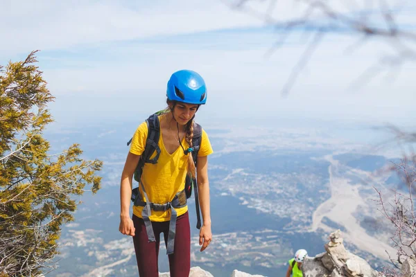 リュックとヘルメットを持って登ると山の山道を進む 女の子は山の中で登る 冒険と登山の概念 山の中でバックパックを持ってハイキングをし — ストック写真