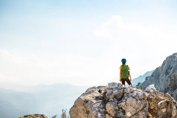 登山家は山の上に立っている ヘルメットとリュックの山に登る少女 山の中の冒険とハイキングという概念です トルコ — ストック写真