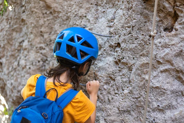ヘルメットを被った少年と山の中のリュックを持った少年 子供は休暇中だ 少年は石を登る — ストック写真