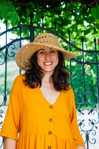 stock image portrait of a young happy brunette in a straw hat. The girl smiles and enjoys her vacation outdoors.Close-up.