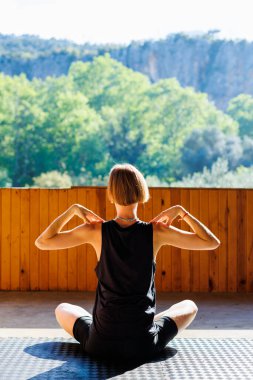 Genç atletik kadın antrenör yoga eğitmeni bireysel antrenman yapıyor. Denge pozisyonu, modern spor salonu, sağlıklı yaşam tarzı konsepti. Doğada spor.