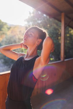 Kız yoga yapıyor. Genç atletik kadın antrenör yoga eğitmeni bireysel antrenman yapıyor. Denge pozisyonu, modern spor salonu, sağlıklı yaşam tarzı konsepti. Doğada spor