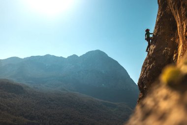 Girl climbs on the rock, rock climbing in Turkey, the sports girl is engaged in rock climbing. extreme sport