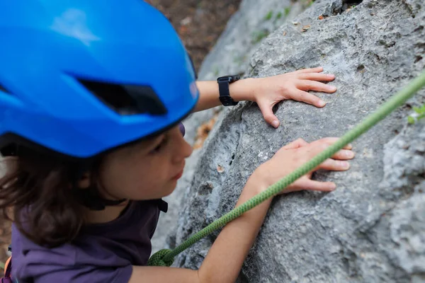 穿着蓝色防护头盔的男孩攀岩者克服了山中的困难 儿童体育的本质 在性质上活跃的时间 — 图库照片
