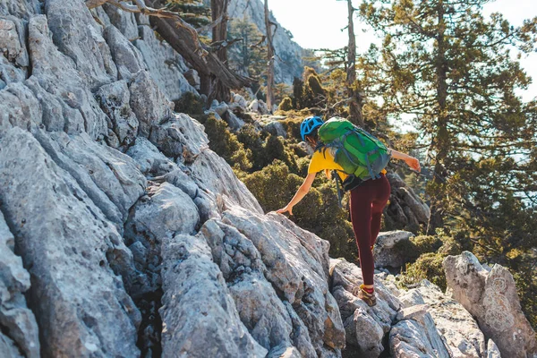 少女は岩に登っている 女性のバックパックと山の中でヘルメットを登る 冒険と登山の概念 山の中のリュックを持ってハイキングをしています トルコの山 — ストック写真