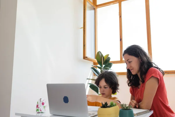 stock image Mother and son do their homework online. distance learning online education. Home education.Schoolboy with laptop and doing homework at school. Mom does homework with her son at home.