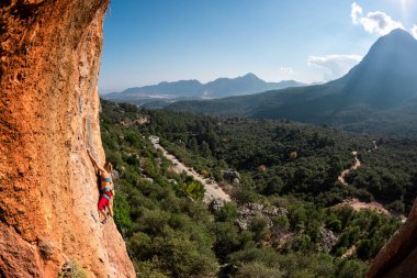 Girl climbs on the rock, rock climbing in Turkey, the sports girl is engaged in rock climbing. extreme sport