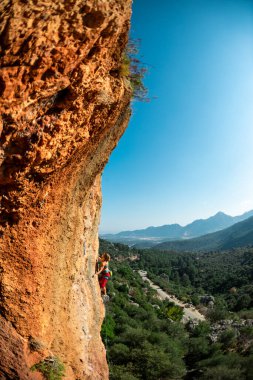 The girl climbs the rock. Climber trains on natural terrain. Extreme sport. Lessons on the street. A woman overcomes a difficult climbing route in Turkey. sports and adventure.