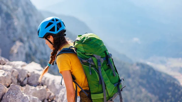 암벽을 오르고 여자는 배낭을 산에서 헬멧을 등산을 등산이라는 개념입니다 가방을 — 스톡 사진