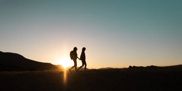 Silhouette Two Girls Backpacks While Traveling Mountains Sunset Two People — Stock Fotó