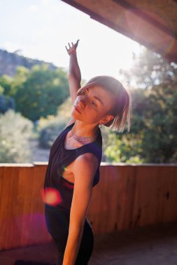 Kız yoga yapıyor. Genç atletik kadın antrenör yoga eğitmeni bireysel antrenman yapıyor. Denge pozisyonu, modern spor salonu, sağlıklı yaşam tarzı konsepti. Doğada spor