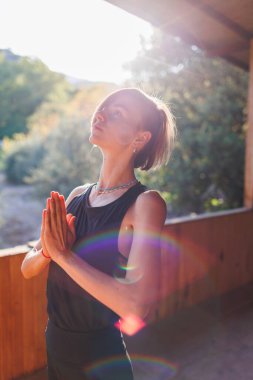 Genç atletik kadın antrenör yoga eğitmeni bireysel antrenman yapıyor. Denge pozisyonu, modern spor salonu, sağlıklı yaşam tarzı konsepti. Doğada spor.