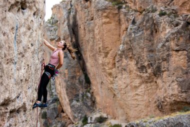 sport climbing. the girl overcomes the climbing route on the rock. sport and fitness.