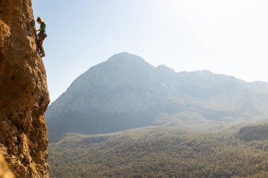 Kız kayalara tırmanıyor, kaya tırmanıyor.