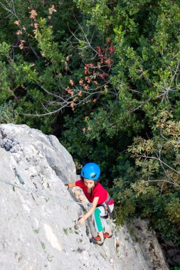 Dağcı çocuk. Çocuk kaya tırmanışı eğitimi alıyor. Doğada spor.