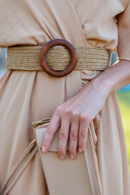 Gece elbisesi giymiş şık bir kız elinde küçük bir çanta tutuyor. Şık aksesuarlar. moda ve tarz kavramı.