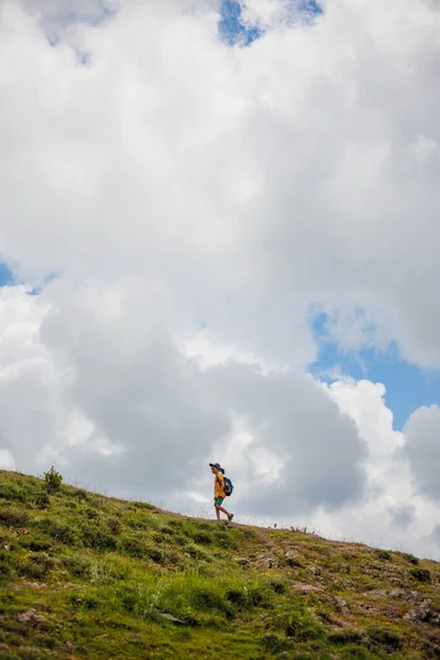 少年は山の雲の背景にバックパックを持って行く バックパック ハイキング ライフスタイルのコンセプトを持つ子供旅行者 — ストック写真