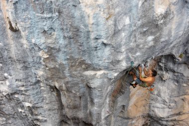 Kaya tırmanışçısı kayaya tırmanır. Güçlü bir adam zor bir yolun üstesinden gelir. Rahatlama ve doğada özgürlük.