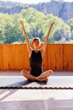 Sokakta esneme hareketleri yapan genç bir kadın. Sağlıklı bir yaşam tarzı. Spor giyimli güzel bir kız yoga yapıyor..